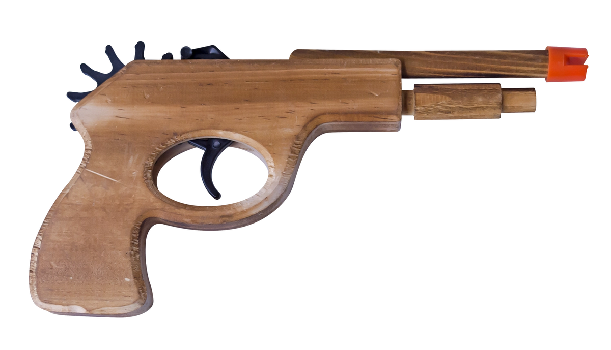 A wooden toy blaster or prop gun with a light brown wood-grain finish, featuring a black trigger and a bright orange tip, isolated on a white background.